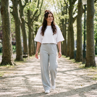 Femme portant le t-shirt manches chauve-souris blanc dans une allée de parc