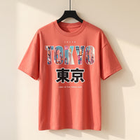 T-shirt oversized enfant rouge corail Tokyo sur cintre, lettrage rempli de néons japonais