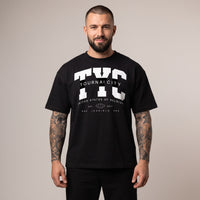 Homme portant le t-shirt oversized noir Tournai City à l'imprimé varsity TYC blanc