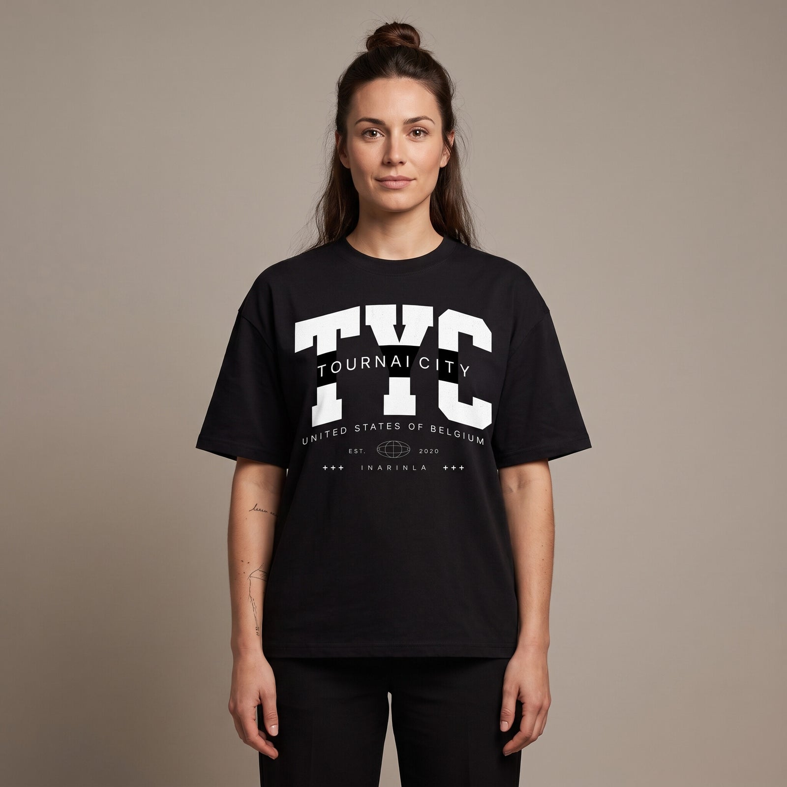 Femme portant le t-shirt oversized noir Tournai City, coupe loose et imprimé universitaire TYC