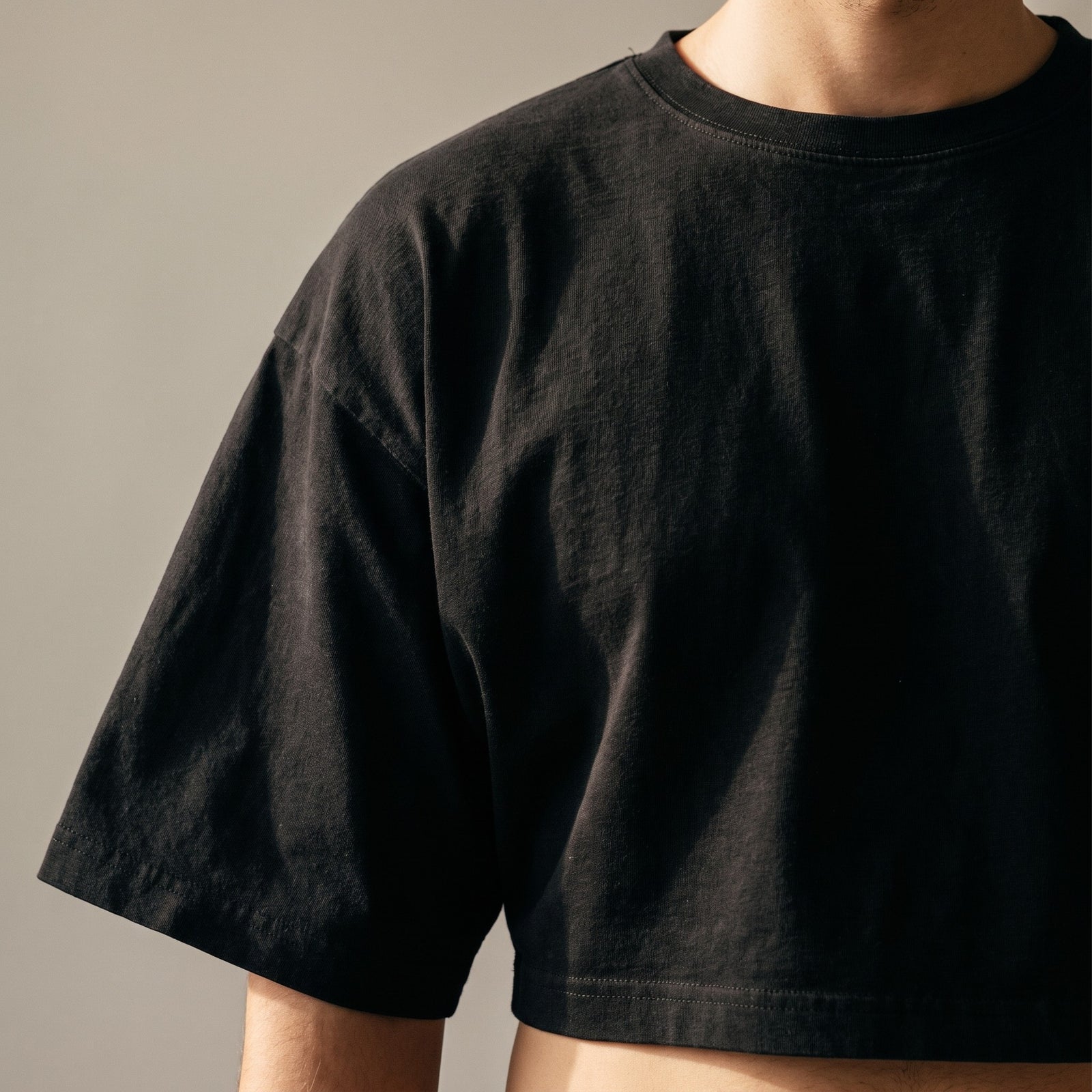 Gros plan du t-shirt boxy original femme noir : coupe, col et texture du tissu