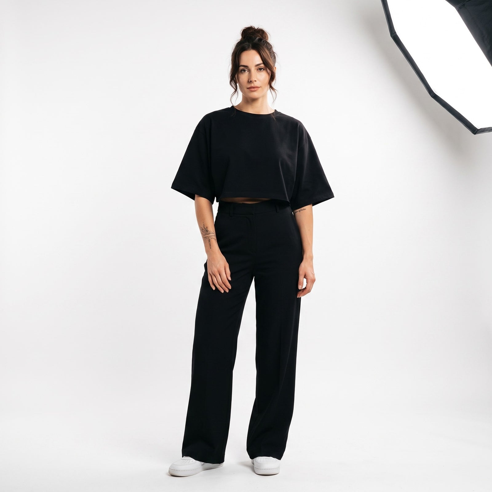 Femme portant le t-shirt boxy original femme noir, photo studio fond blanc