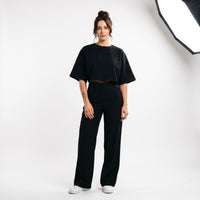 Femme portant le t-shirt boxy original femme noir, photo studio fond blanc