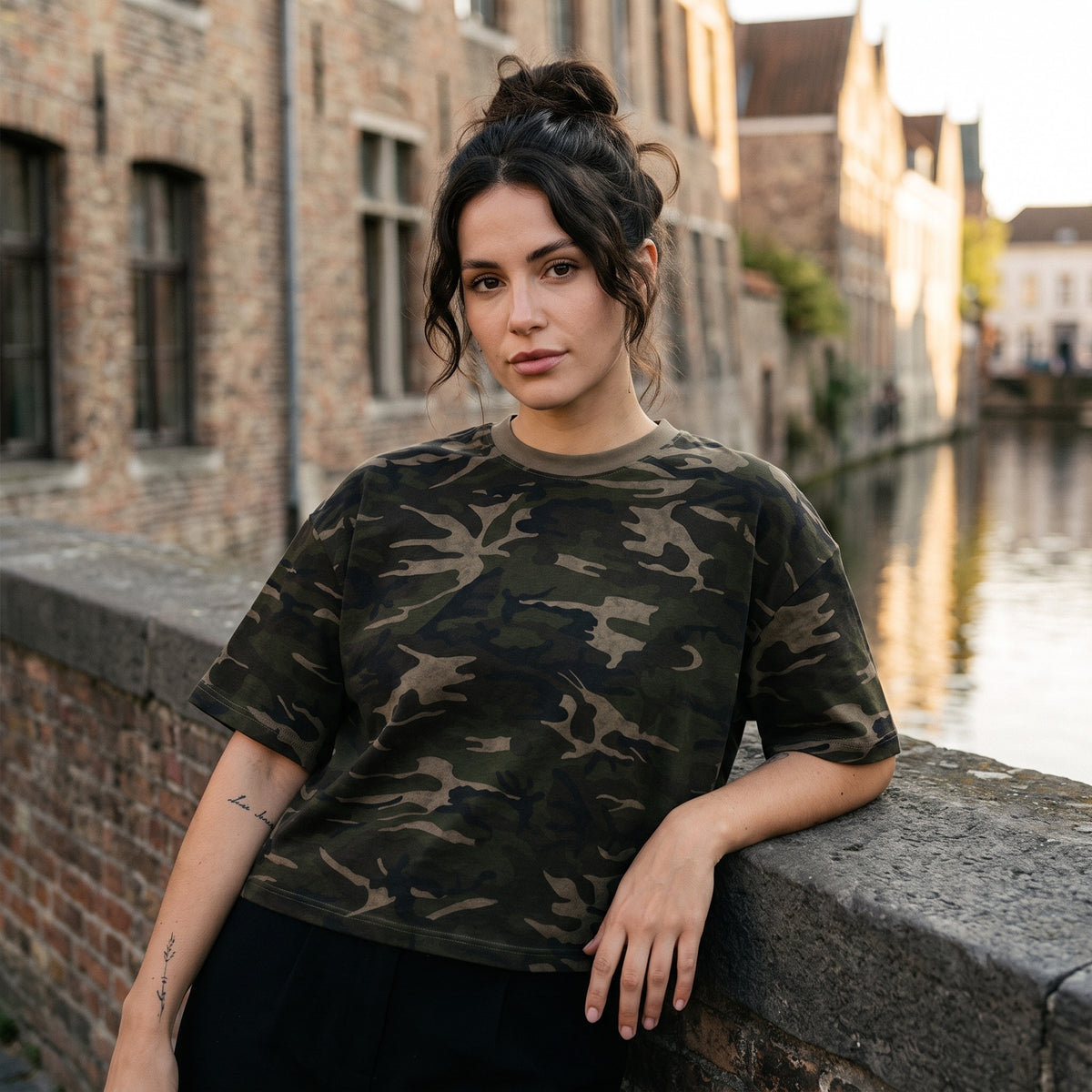 T-shirt camouflage boxy kaki CHT'M porté par une femme sur un pont de canal en Belgique