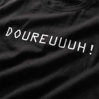 Gros plan du design Doureuuuh imprimé en blanc sur le t-shirt oversize noir