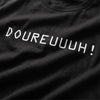 Gros plan du design Doureuuuh imprimé en blanc sur le t-shirt oversize noir