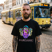 Homme en t-shirt original DOUREUUUH ! noir dans une rue de briques belge, ambiance streetwear