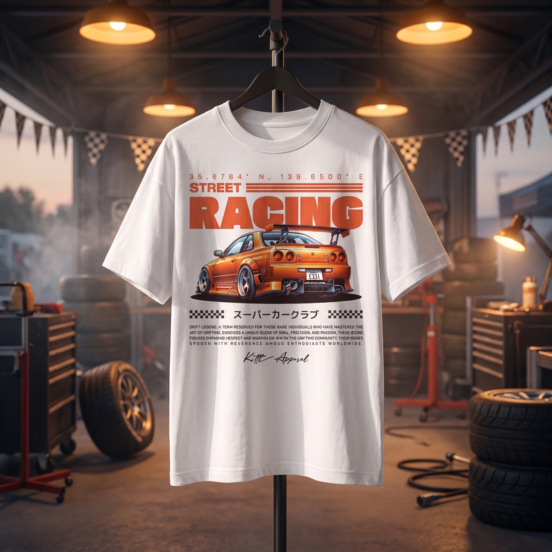 T-shirt oversized enfant Street Racing blanc, imprimé voiture de course japonaise orange, présenté sur support dans un garage de course éclairé au coucher de soleil