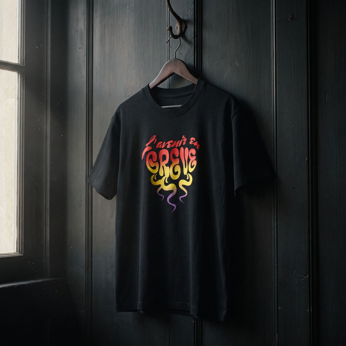 T-shirt Gen Z noir « L'avenir en grève » psychédélique sur cintre en bois – t-shirt manif original CHT'M