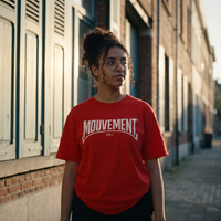 Lycéenne en t-shirt Gen Z rouge « Mouvement » logo blanc dans une rue en briques – tshirt genz pas cher CHT'M