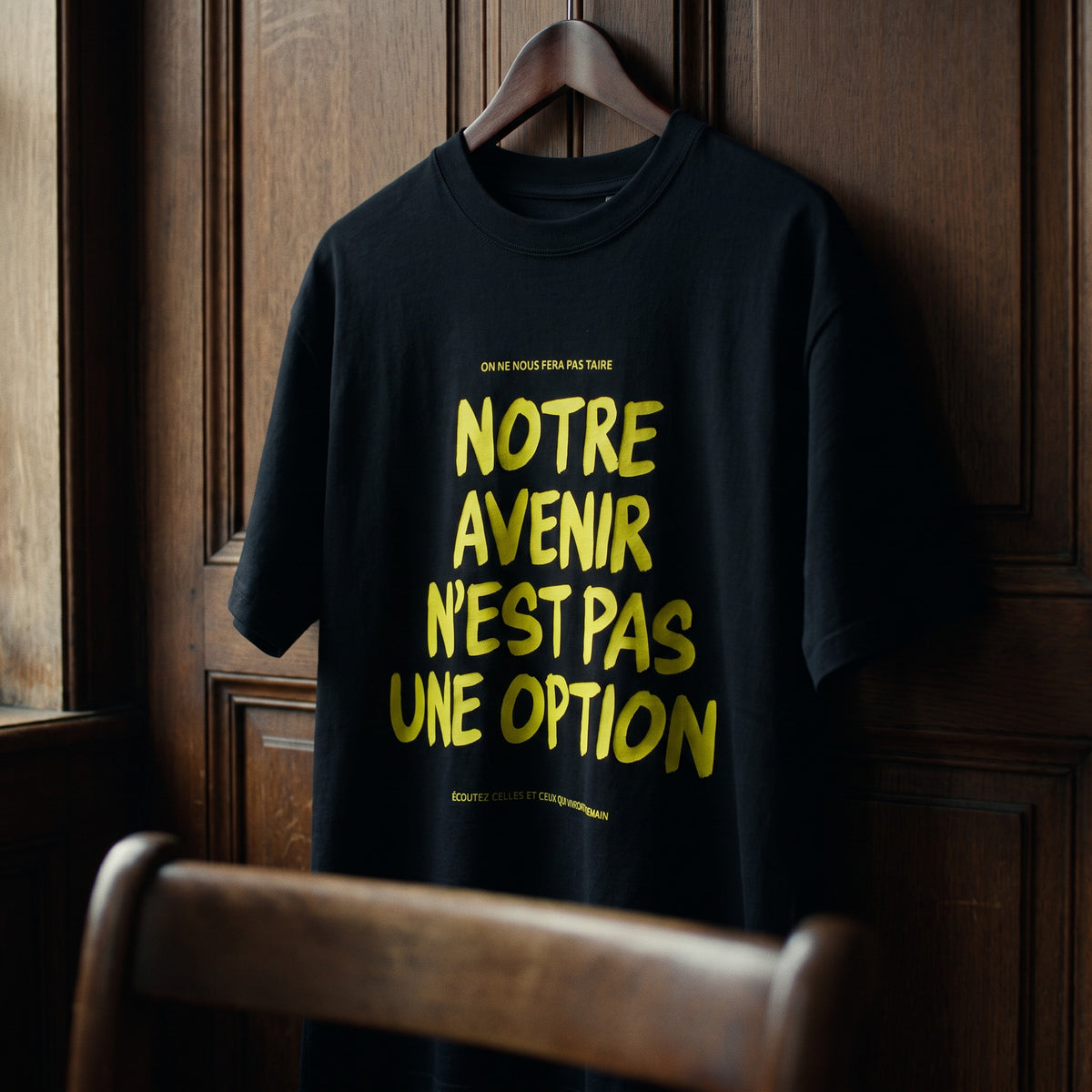 Gros plan du t-shirt Gen Z noir « Notre avenir n'est pas une option » sur cintre, vue trois-quarts – CHT'M Boutique