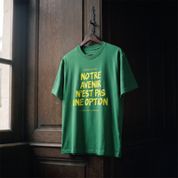 T-shirt Gen Z vert prairie « Notre avenir n'est pas une option », slogan jaune fluo, sur cintre en bois dans un intérieur sombre – t-shirt manif original CHT'M
