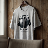 Gros plan du t-shirt Gen Z gris avoine « Stay Strong la Gène Z » sur cintre – CHT'M Boutique