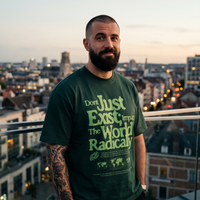 T-shirt oversized Impact The World Radically vert foncé porté par un homme sur un rooftop à Bruxelles au crépuscule