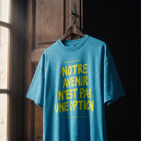 T-shirt oversized délavé Gen Z bleu lagon « Notre avenir n'est pas une option », slogan jaune fluo, sur cintre en bois – t-shirt manif original CHT'M