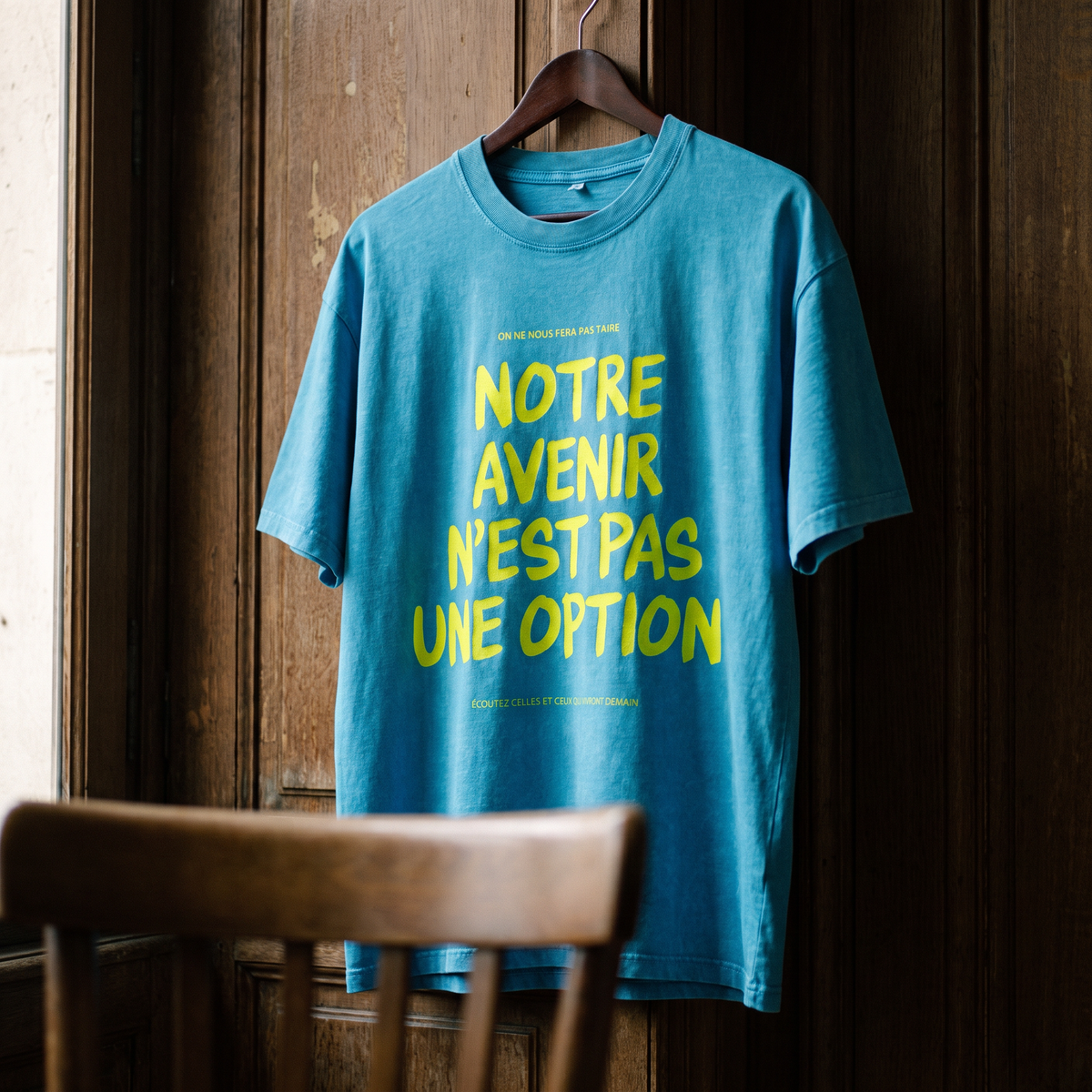 Gros plan du t-shirt oversized délavé Gen Z bleu lagon « Notre avenir n'est pas une option » sur cintre – CHT'M Boutique