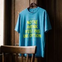 Gros plan du t-shirt oversized délavé Gen Z bleu lagon « Notre avenir n'est pas une option » sur cintre – CHT'M Boutique