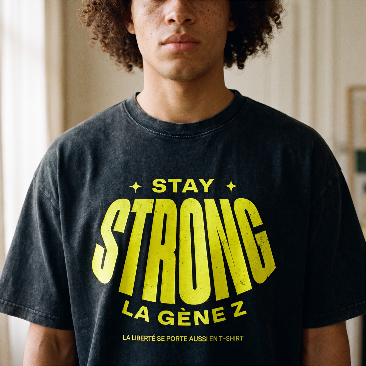 Gros plan du print jaune fluo « Stay Strong la Gène Z » sur le t-shirt oversized délavé noir porté – CHT'M Boutique