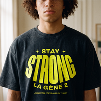 Gros plan du print jaune fluo « Stay Strong la Gène Z » sur le t-shirt oversized délavé noir porté – CHT'M Boutique