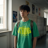 Lycéen portant le t-shirt oversized délavé Gen Z vert prairie « Stay Strong la Gène Z » dans un couloir de lycée – t-shirt manif pas cher CHT'M