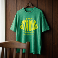 Gros plan du t-shirt oversized délavé Gen Z vert prairie « Stay Strong la Gène Z » sur cintre – CHT'M Boutique