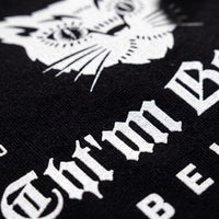 Macro de l'impression blanche du logo chat sur le coton noir du t-shirt oversized CHT'M