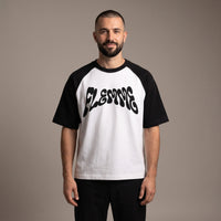 Homme portant le t-shirt raglan FLEMME blanc à manches noires, coupe oversize unisexe