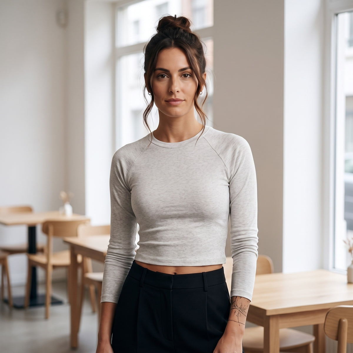Femme portant le t-shirt manches longues original femme raglan slim gris avoine, ambiance urbaine et lumière naturelle