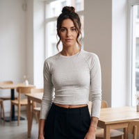Femme portant le t-shirt manches longues original femme raglan slim gris avoine, ambiance urbaine et lumière naturelle