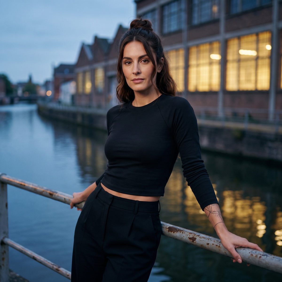 Femme portant le t-shirt manches longues original femme raglan slim noir, style streetwear urbain au bord du canal de Bruxelles