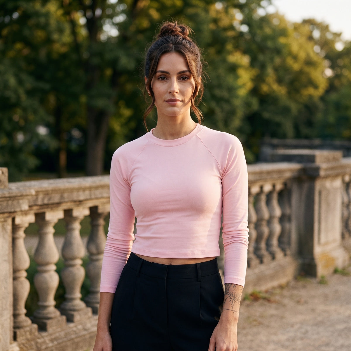 Femme portant le t-shirt manches longues original femme raglan slim rose, look streetwear dans un cadre urbain