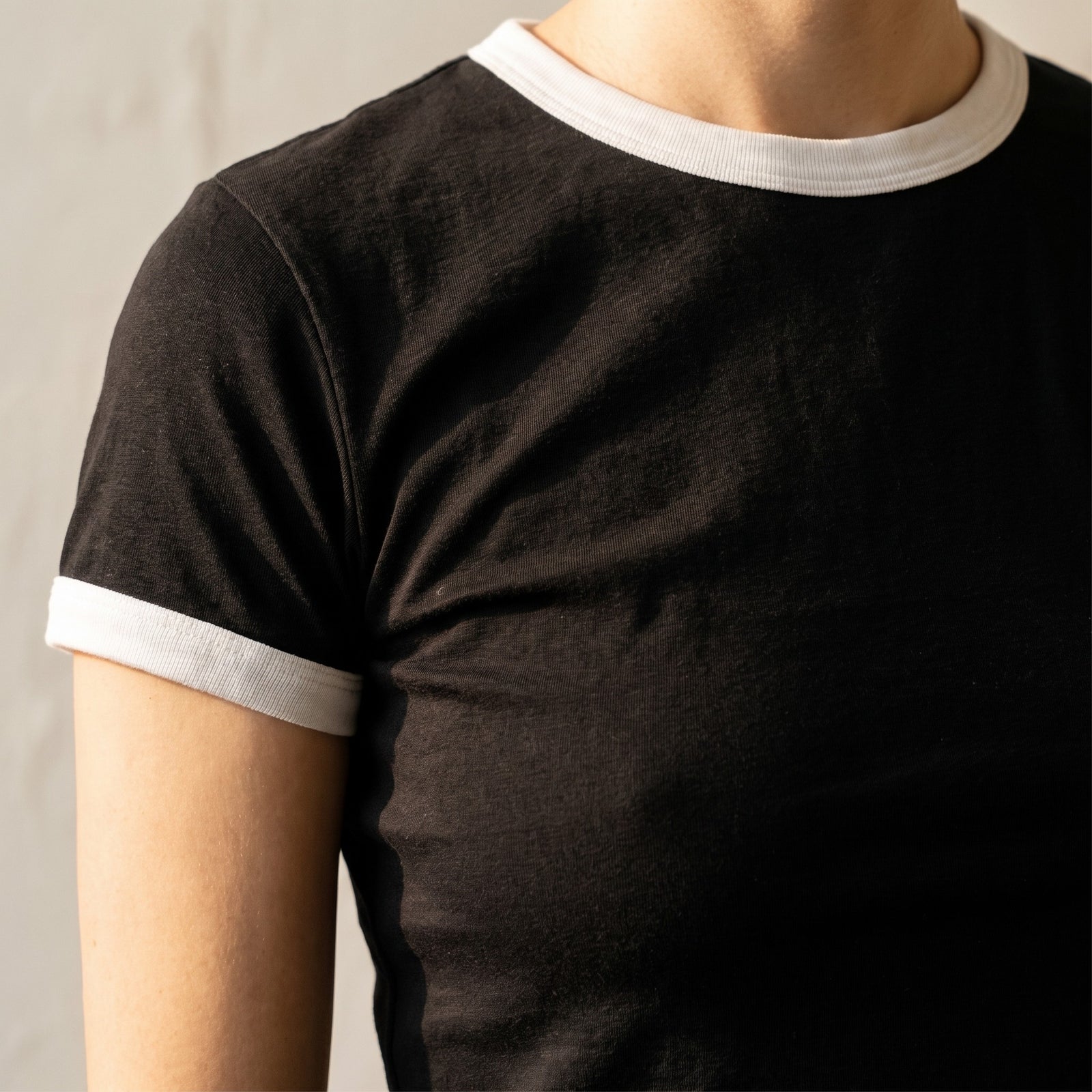 Gros plan du t-shirt ringer original femme noir et blanc : col et manches contrastés