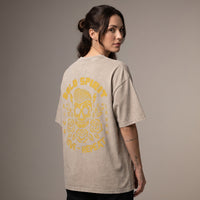 Femme portant le t-shirt beige sable de dos, grand imprimé tête de mort Bold Spirit jaune ocre