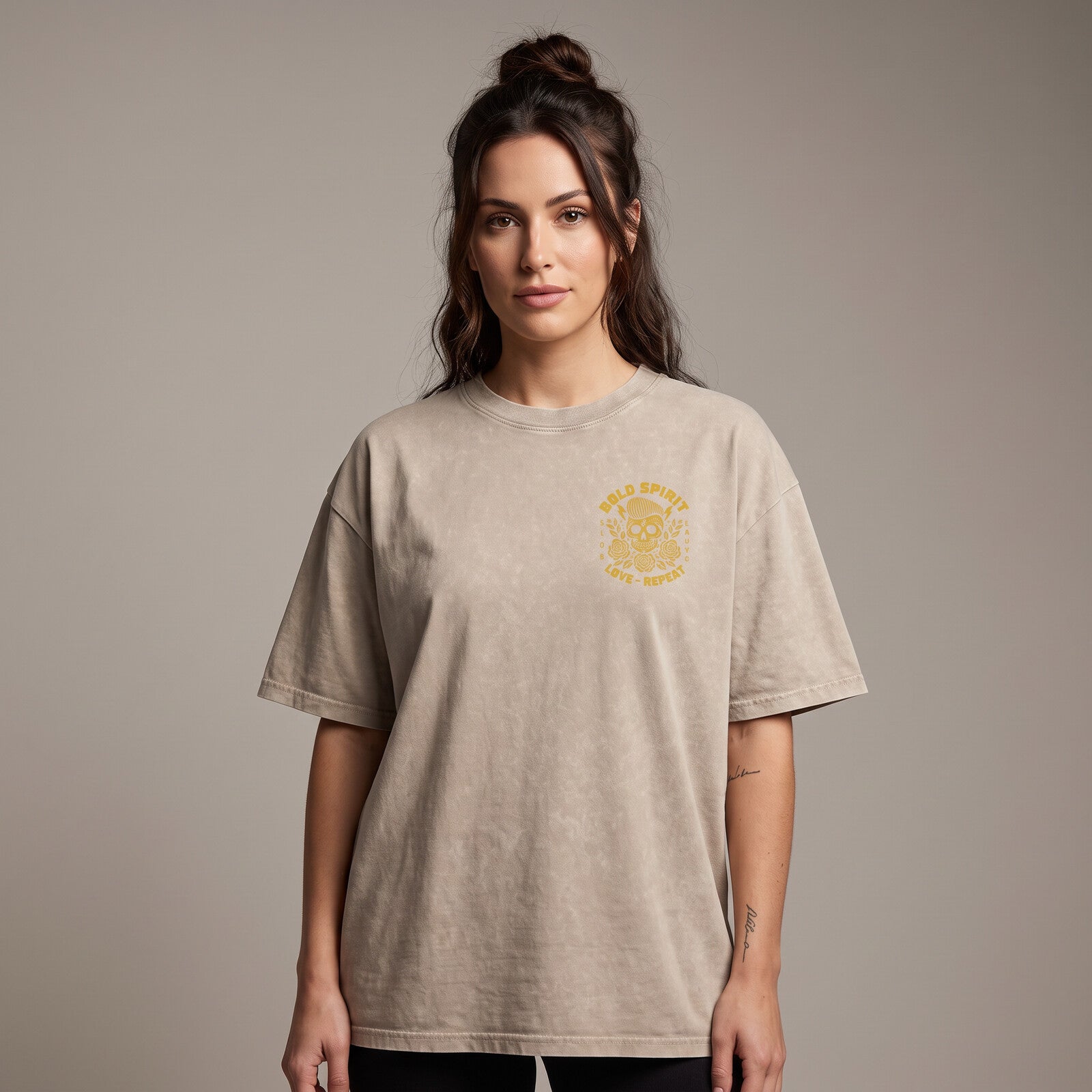 Femme portant le t-shirt tête de mort beige sable oversize vu de face, badge Bold Spirit sur la poitrine