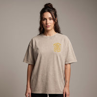 Femme portant le t-shirt tête de mort beige sable oversize vu de face, badge Bold Spirit sur la poitrine