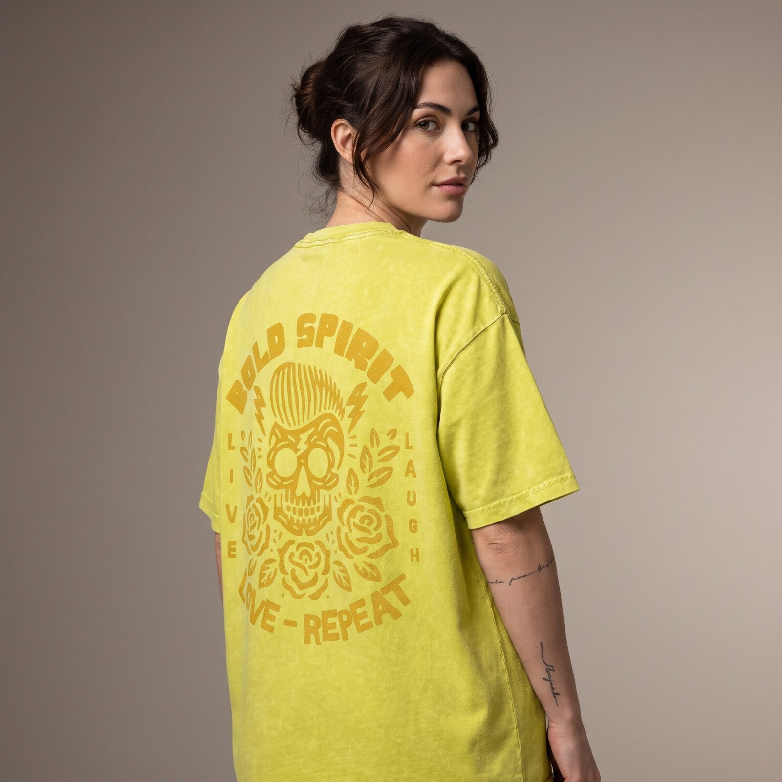 Femme portant le t-shirt jaune olive de dos, grand imprimé tête de mort Bold Spirit jaune ocre