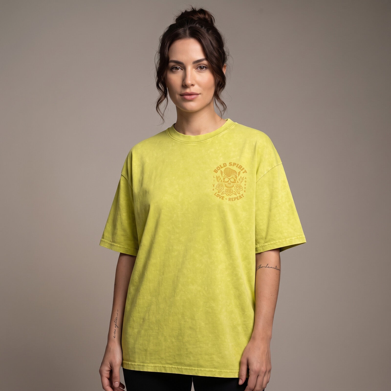 Femme portant le t-shirt tête de mort jaune olive oversize vu de face, badge Bold Spirit sur la poitrine
