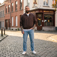 Homme portant la veste Harrington à carreaux bordeaux devant un pub belge