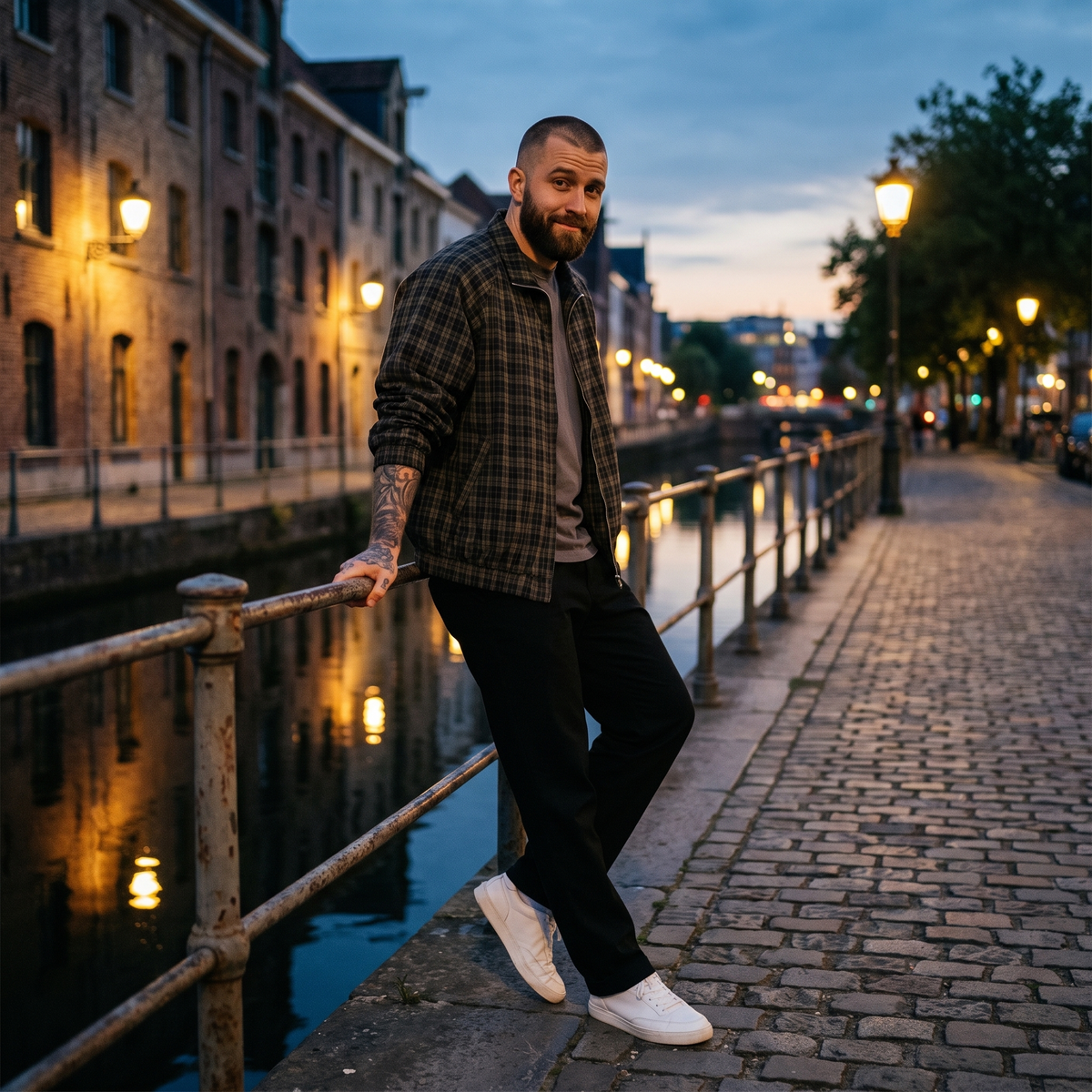 Homme portant la veste Harrington à carreaux noire au bord d'un canal belge