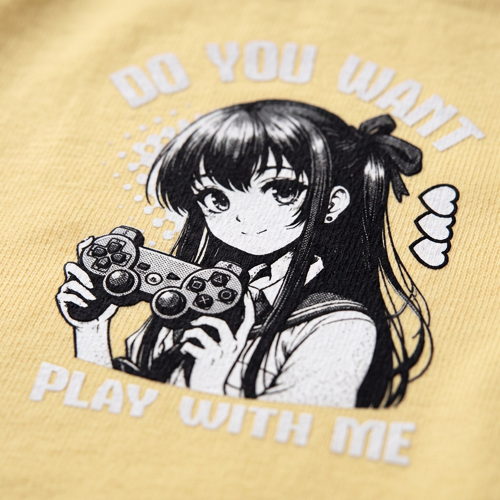 Gros plan sur l'impression manga noir et blanc de la gameuse a la manette sur coton jaune pale