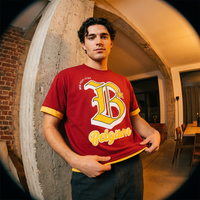 Homme en t-shirt belge color block rouge et jaune Belgium B devant un mur en béton