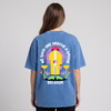 T-shirt belge original « Né sous une drache d'amour » porté de dos par une femme, imprimé XXL complet visible en studio sur coton bleu snow wash