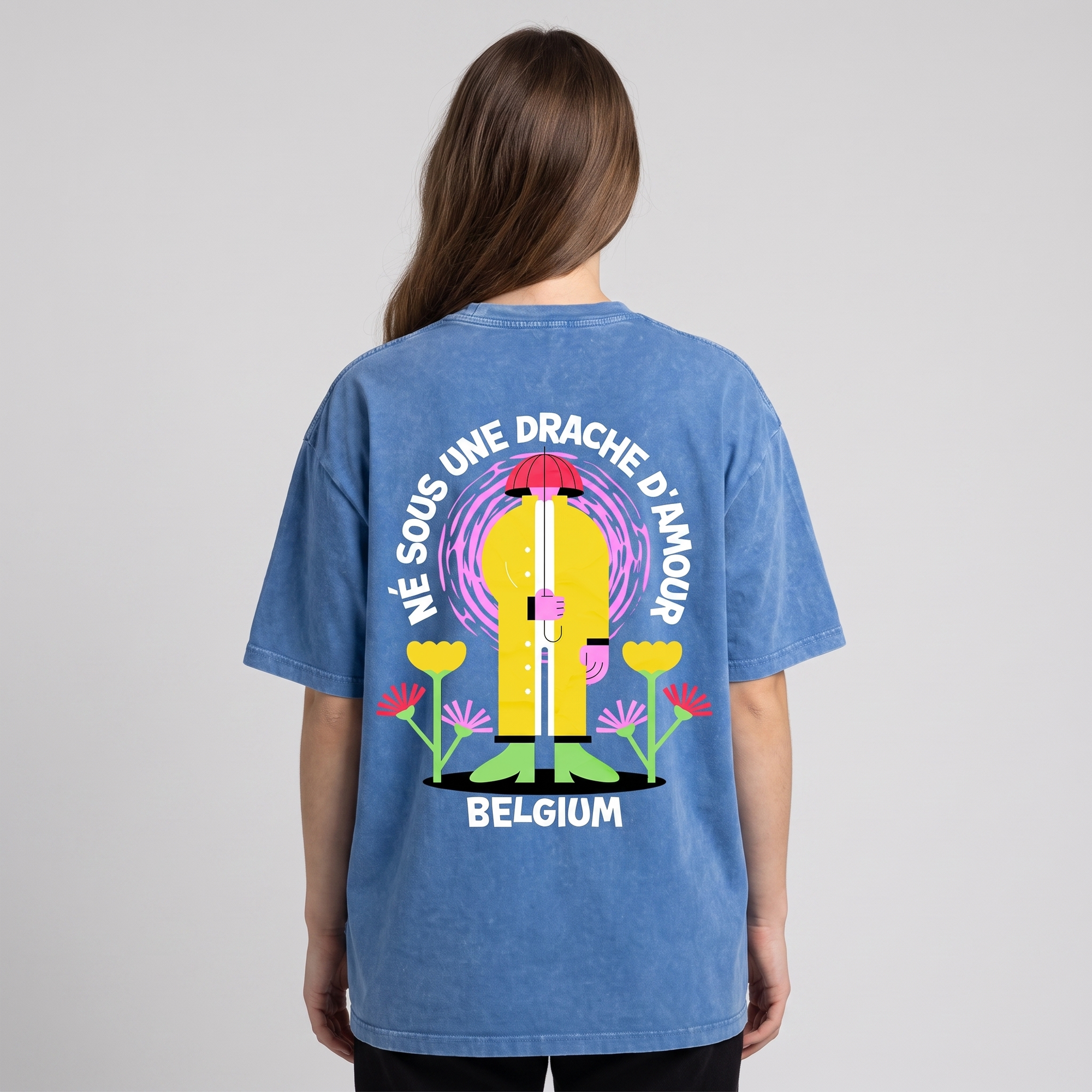 T-shirt belge original « Né sous une drache d'amour » porté de dos par une femme, imprimé XXL complet visible en studio sur coton bleu snow wash