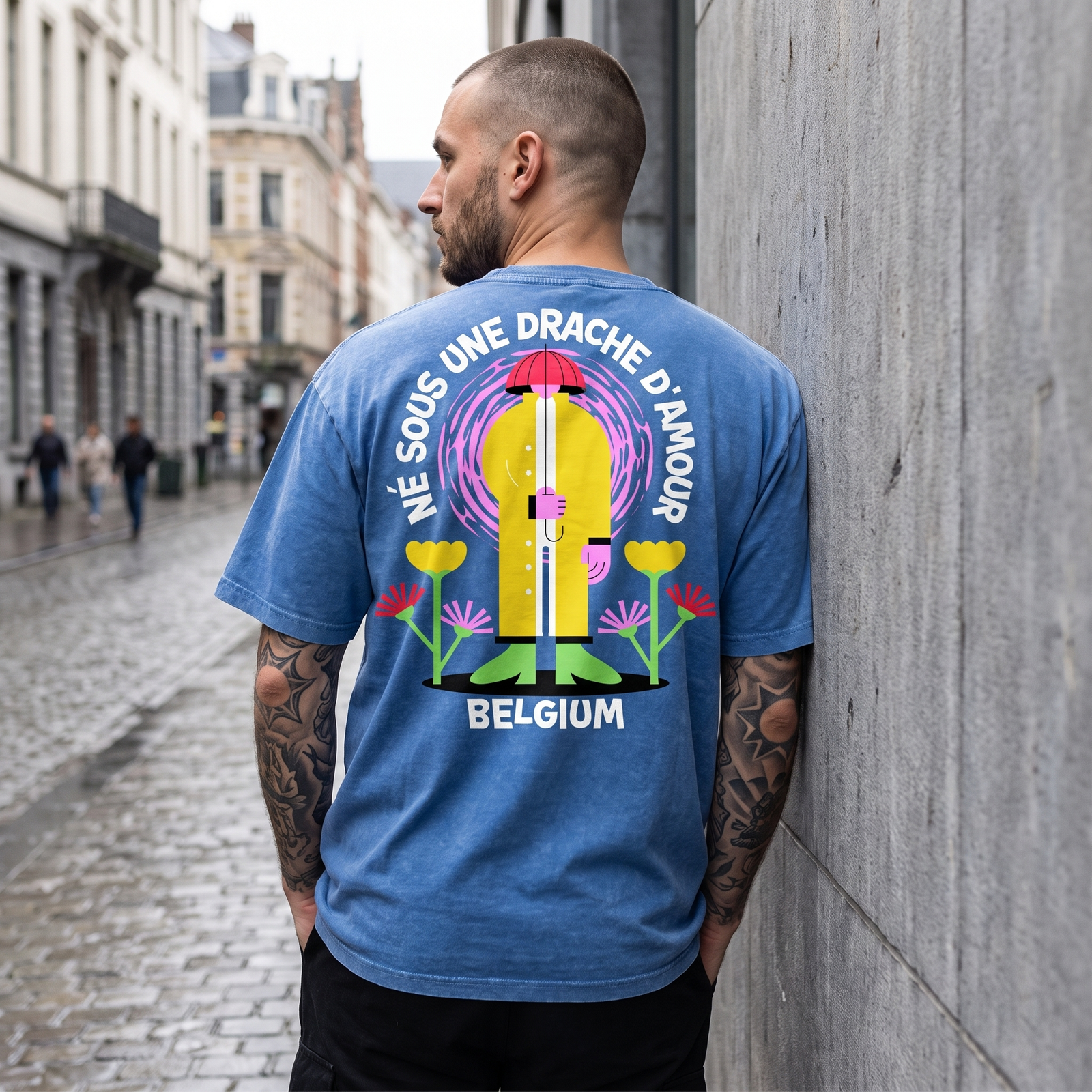 Homme tatoué de dos dans une rue de Bruxelles, dos du t-shirt belge drache d'amour bien lisible