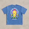 T-shirt belge « Né sous une drache d'amour » à plat, dos avec le design complet en gros plan sur coton bleu snow wash