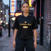 Femme portant le maillot Golden Tich noir en soirée – rue animée, design doré Golden Tich et badge BXL