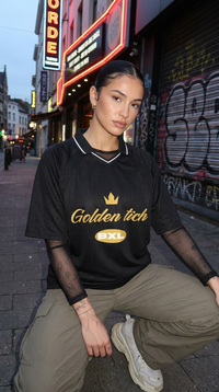 Maillot Golden Tich noir porté par une femme – ambiance néon nocturne, manches mesh, look streetwear BXL