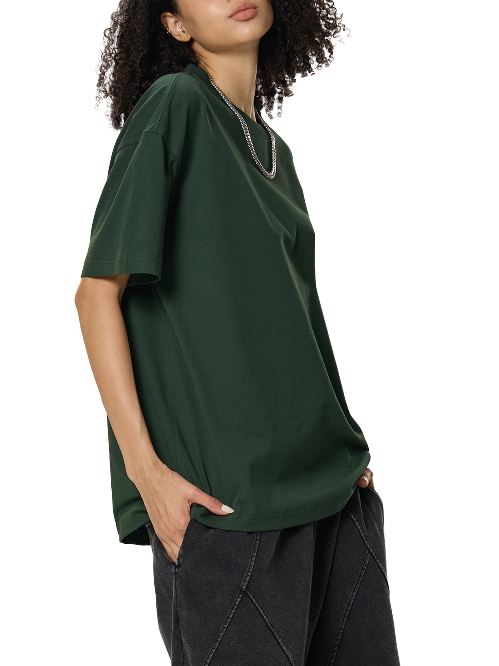 Mannequin femme de trois quarts en t-shirt oversized Sorona vert foncé, drapé souple de la maille