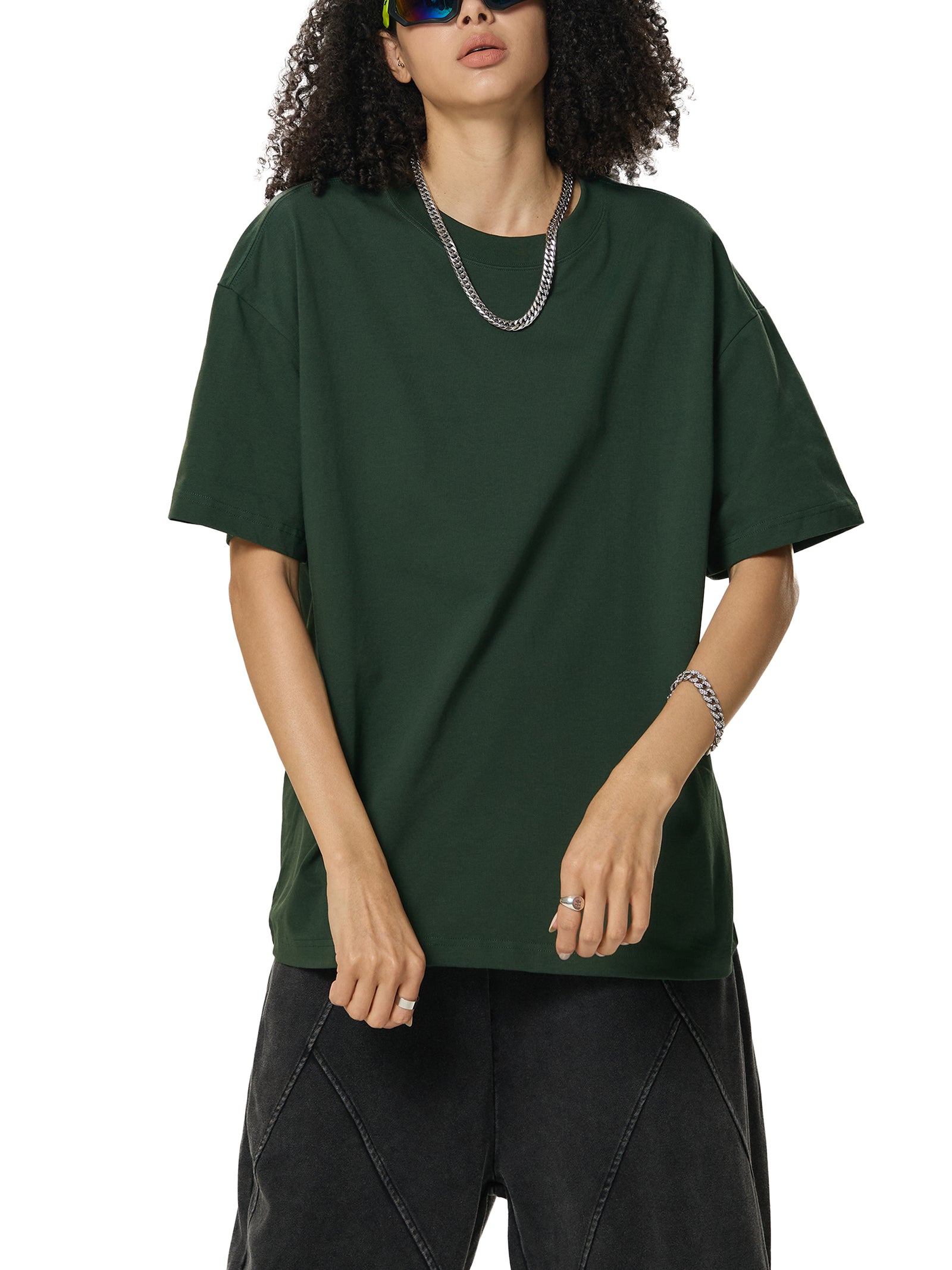 T-shirt oversized Sorona vert foncé porté avec un pantalon délavé, allure streetwear décontractée