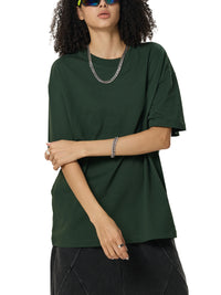 Mannequin femme en t-shirt oversized Sorona vert foncé, bras croisés, largeur de la coupe loose